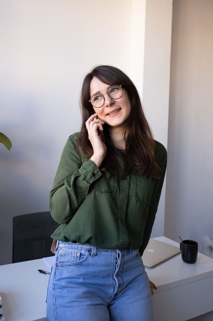 Louise Carreno, webdesigner, souriante au téléphone à son bureau
